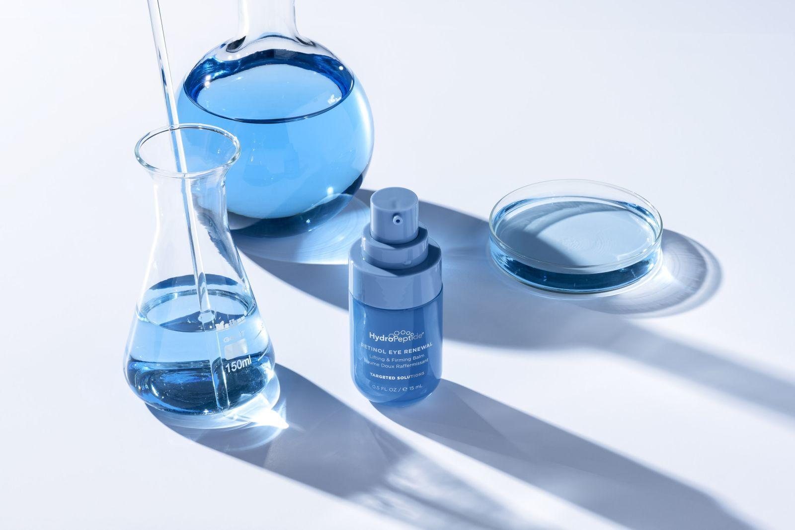 HydroPeptide Retinol Eye Renewal tussen blauwe laboratoriumglazen