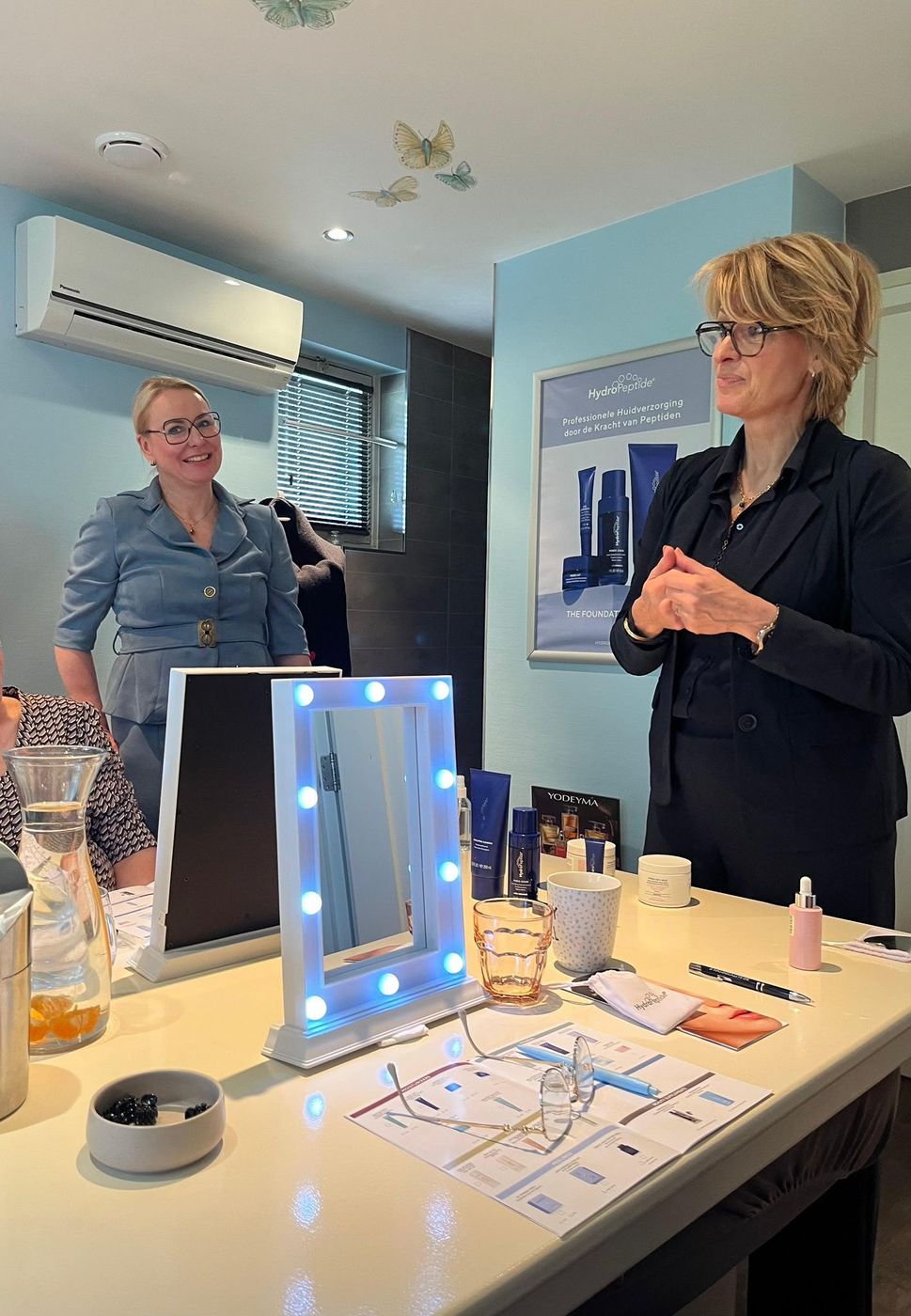 Twee vrouwen tijdens een HydroPeptide-presentatie met een lichtspiegel