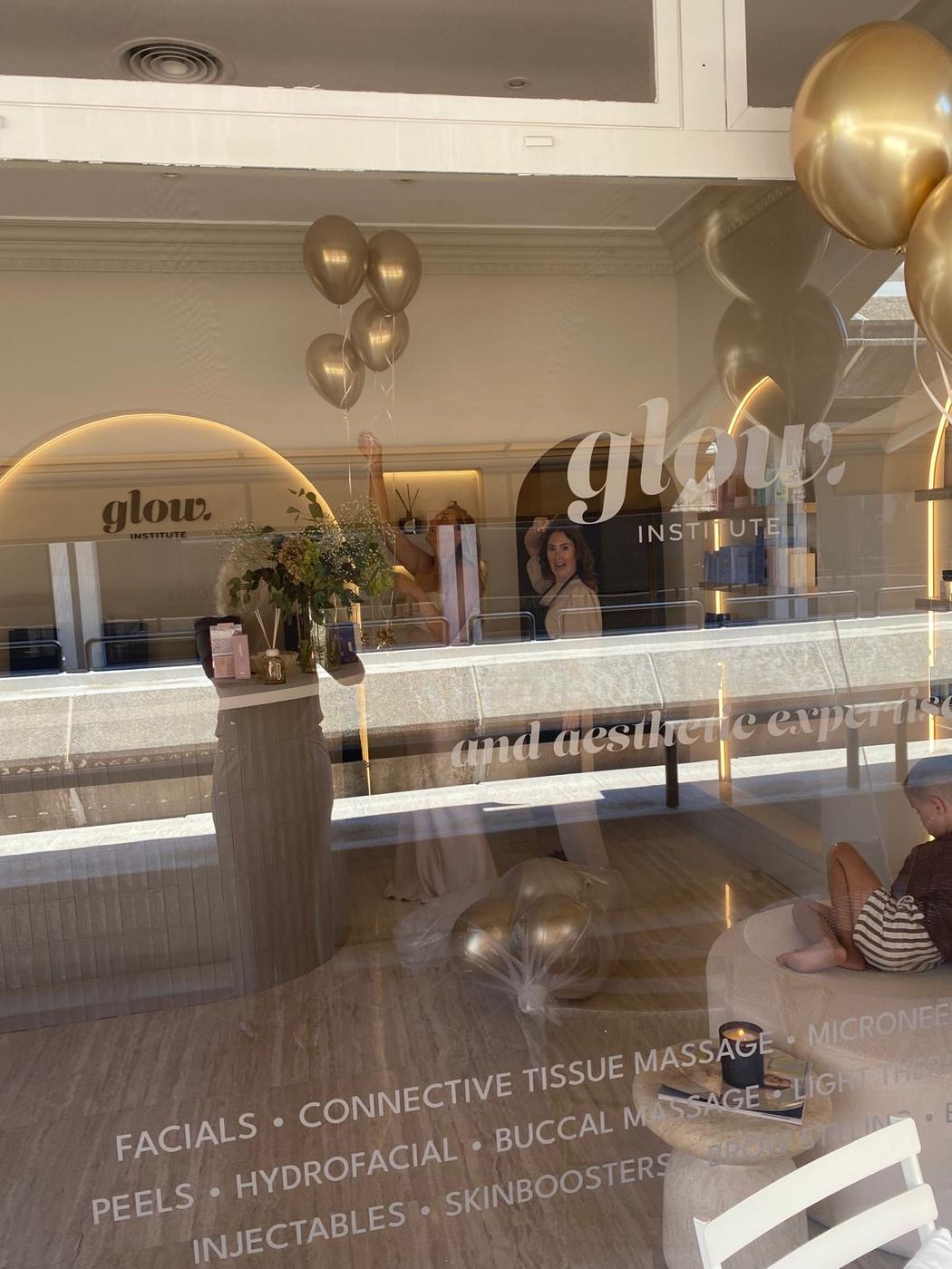 Etalage van Glow Institute met gouden ballonnen