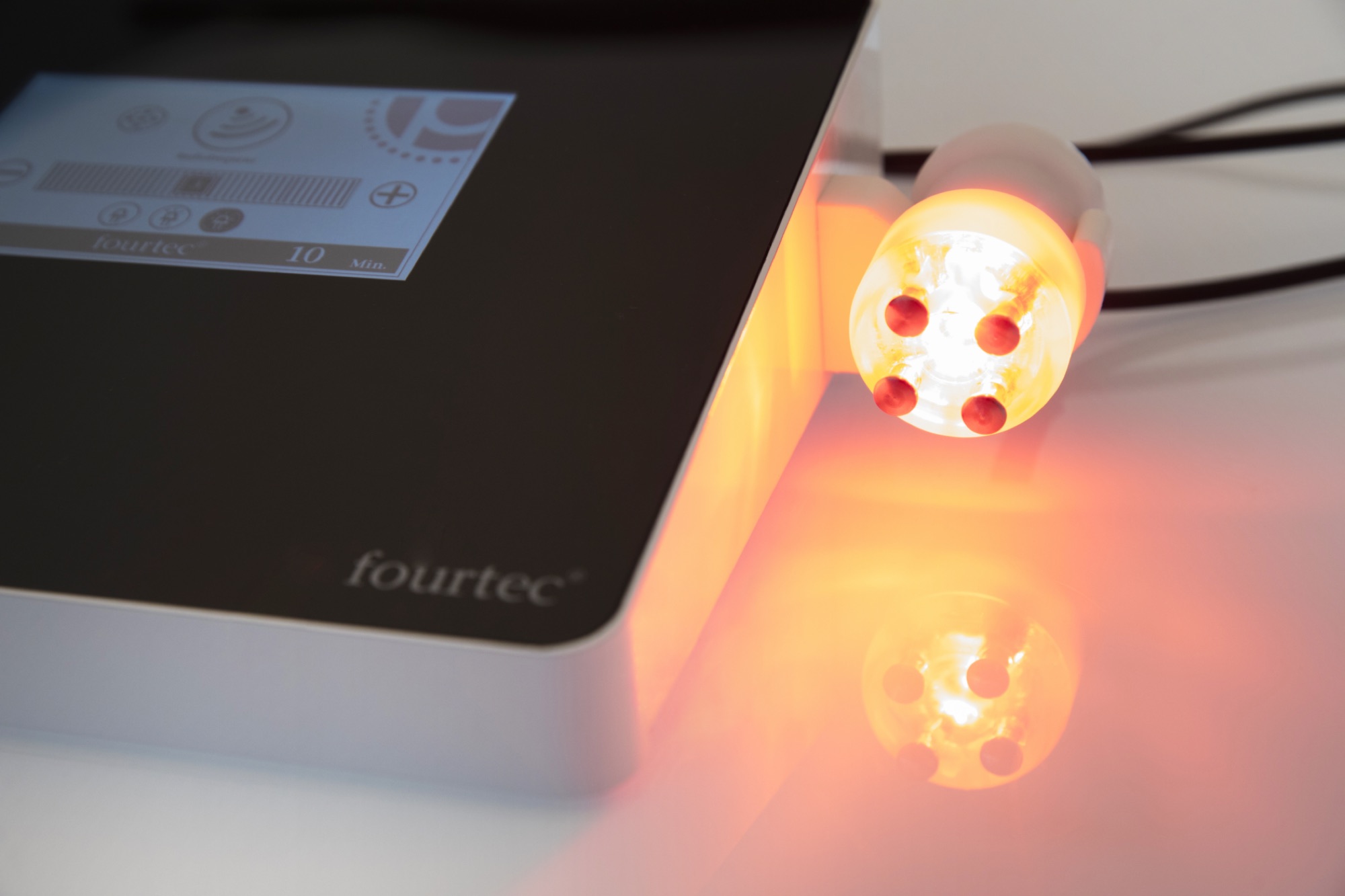 Fourtec apparaat met behandelkop in oranje licht