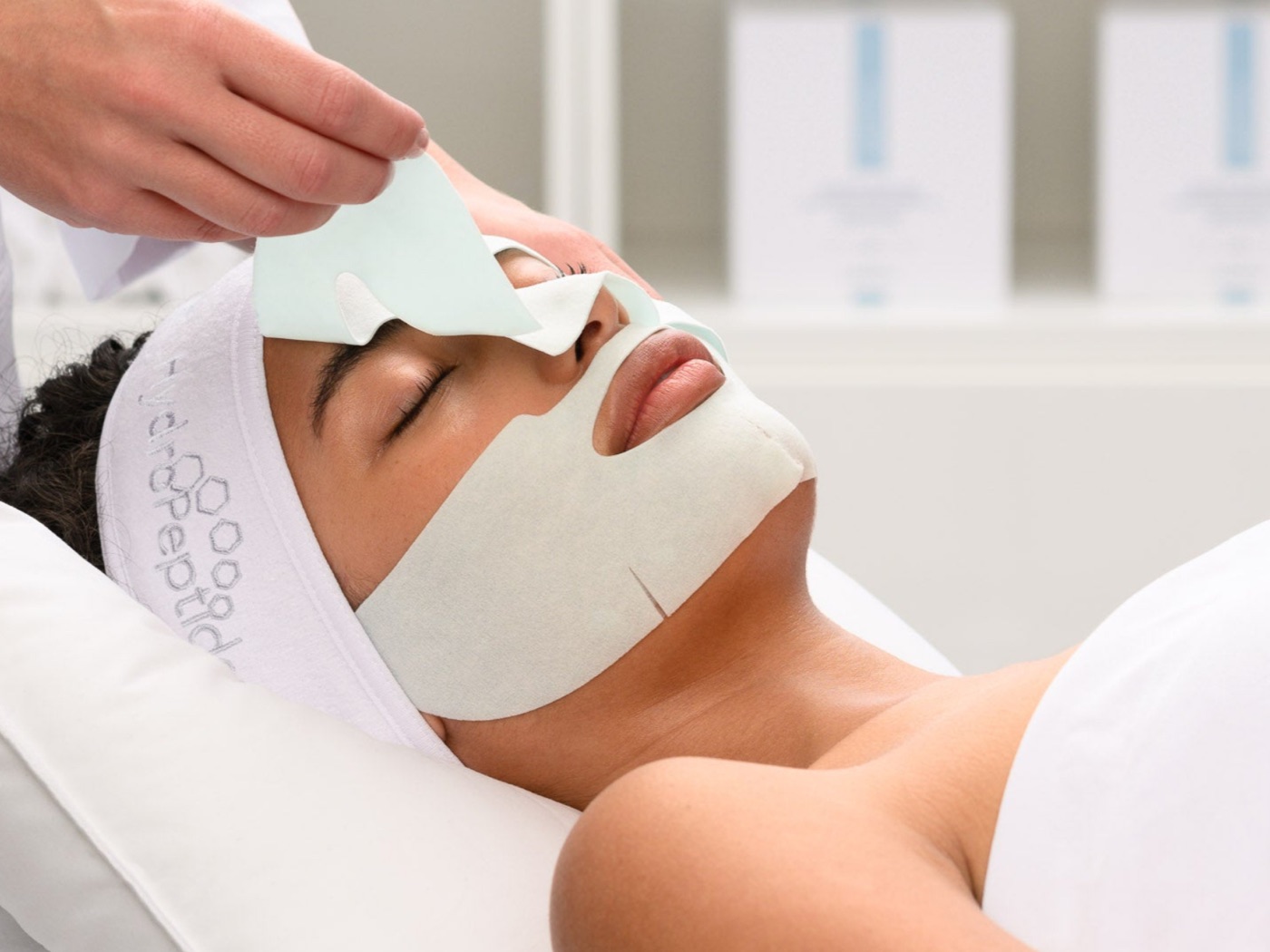 Behandelaar verwijdert een HydroPeptide gezichtsmasker