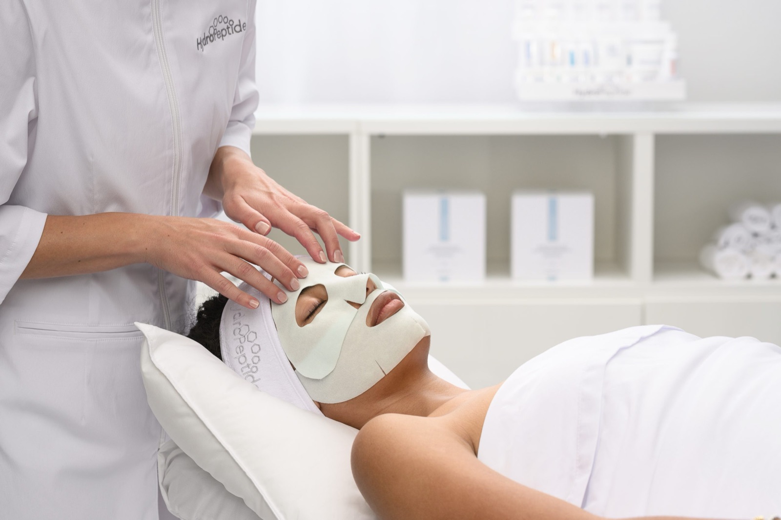 Behandelaar legt een HydroPeptide gezichtsmasker aan