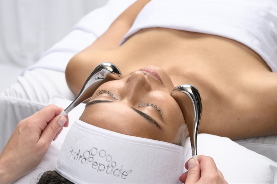 Behandelaar werkt met HydroPeptide gezichtsmassage-tools